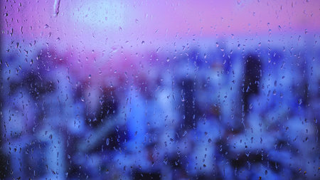 Rain drops on window with purple and blue city lights