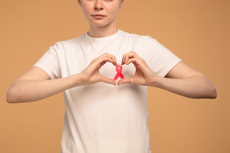 Woman Holding Pink Ribbon Symbolizing Breast Cancer Awarenessの写真素材