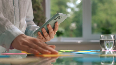 Person Organizing Colorful Sticky Notes Using Smartphone at Desk