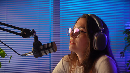 Young Woman in Studio with Microphone and Headphones Recording Podcastの写真素材