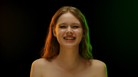 Smiling Woman with Brown Hair in Colorful Lightingの写真素材