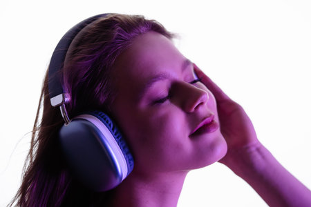 Young Woman Enjoying Music Through Large Comfortable Headphonesの写真素材