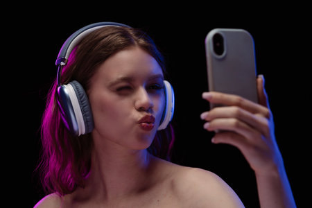 Woman Enjoying Music and Taking a Selfie with Smartphoneの写真素材