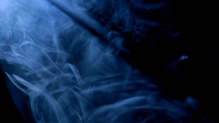 Swirling blue smoke in the darkの写真素材