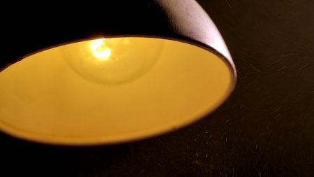Warm light from vintage lamp with visible dust particlesの写真素材