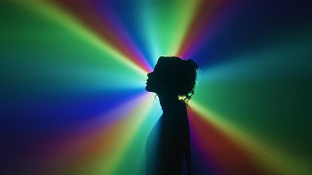 Silhouette of woman in rainbow light burstの写真素材