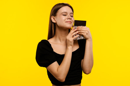 Woman Enjoying Aromatic Coffee in Bright Yellow Backgroundの写真素材