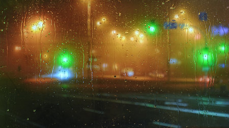 Colorful city lights through rainy window glassの写真素材
