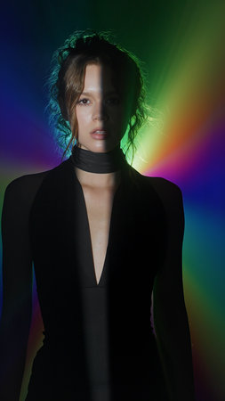 Woman in rainbow spotlight with dramatic contrast
