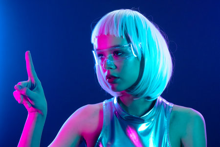 Futuristic woman in neon light pointing up
