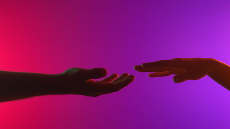Hands Reaching Toward Each Other in Colorful Light