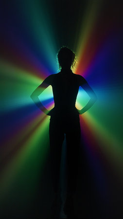 Silhouette of woman in rainbow light burst