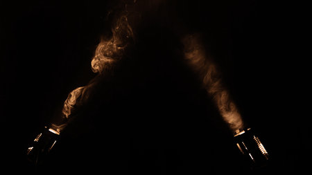 Bright spotlights beam from professional lighting equipment sparkle in the dark with floating smoke.