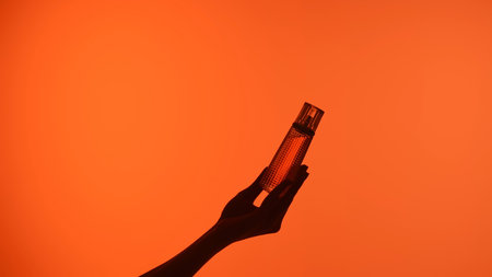 Silhouette of Hands Holding a Perfume Bottleの写真素材