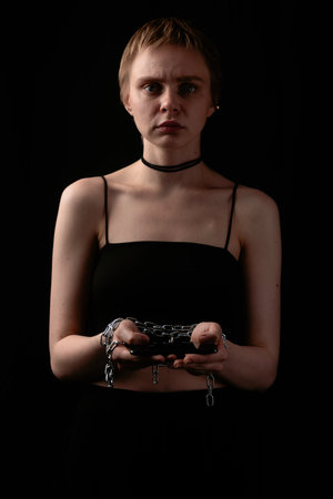 Young Woman in Dark Outfit Holding Chains Symbolism
