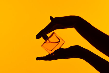 Silhouette of Hands Holding a Perfume Bottleの写真素材