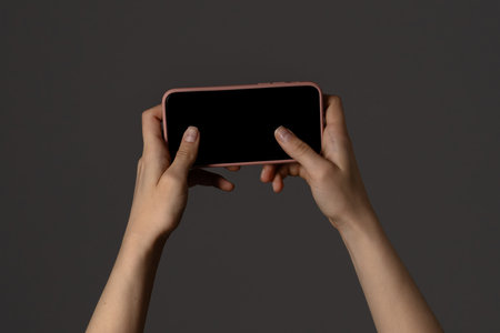 Person Holding Smartphone with Black Screen Horizontally