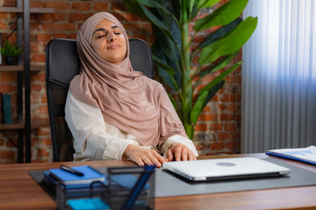 Relaxed Woman Sitting in Office Chair Near Desk Areaの写真素材