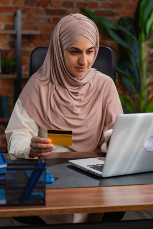 Middle Eastern Muslim woman in beige hijab working in an officeの写真素材