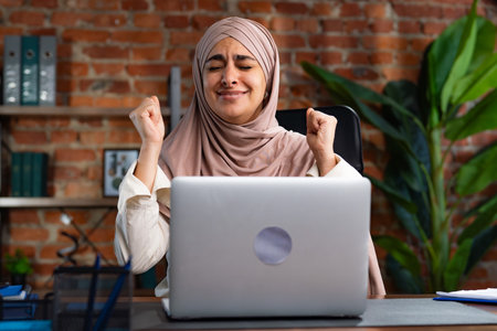 Joyful Woman Celebrating Successful Achievement at Workの写真素材