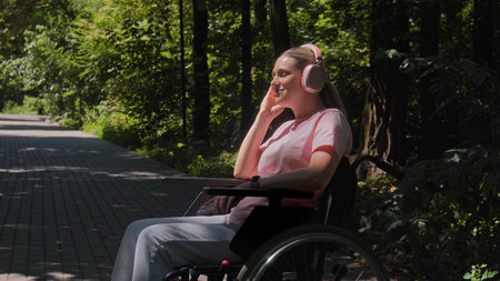 Woman in wheelchair with headphones enjoying nature in park