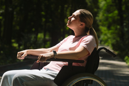 Young Woman in Wheelchair Enjoying Nature in the Parkの写真素材