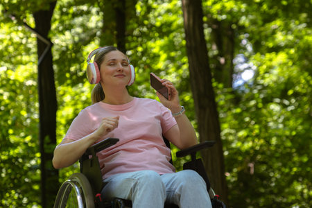 Young Woman Enjoying Music Outdoors in a Wheelchairの写真素材