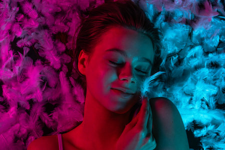 Soft neon beauty top shot with feathers for skincare and wellness vibe