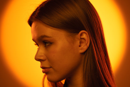 Profile Portrait of a Woman in Warm Orange Lighting