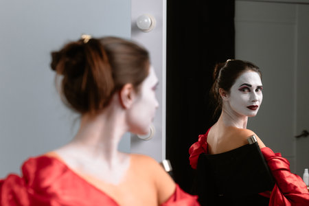 Woman in Dramatic Makeup Sitting at a Mirrorの写真素材
