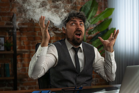 Businessman works in a loft style office and experiences stress from overwork