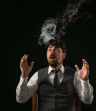 Male businessman on black background in white smoke cloudsの写真素材