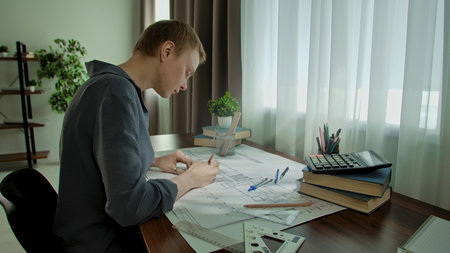 Young Architect Working Diligently on Architectural Drawings