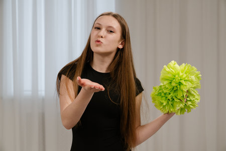 Young teenager girl spending time at training, girl in sportswear attends cheerleaders training...