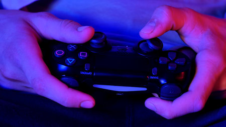 Hands Holding a Modern Video Game Controllerの写真素材