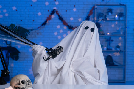 Ghost costume recording podcast or blog in a studio with blue light