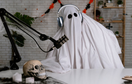 Funny ghost in a white sheet recording a podcast or blog