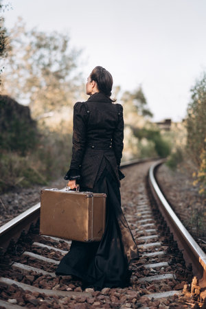Woman with Vintage Suitcase on Railroad Tracks in Autumn