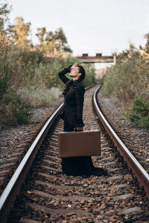 Woman with Vintage Suitcase on Railroad Tracks in Autumn