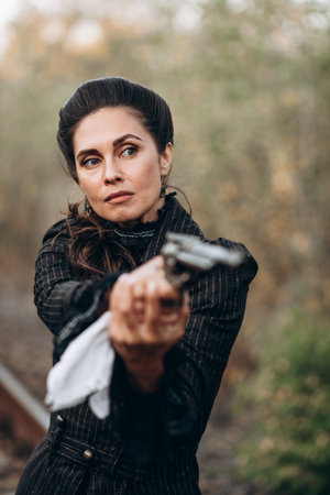 Woman Aiming Revolver in Vintage Attire Outdoorsの写真素材