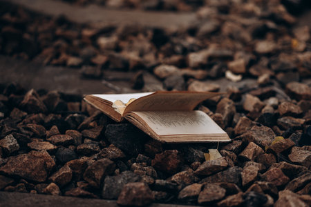 Open book on rocky surface surrounded by scattered stonesの写真素材