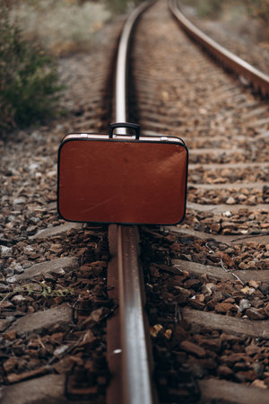 Abandoned Suitcase on Railway Tracks at Sunsetの写真素材