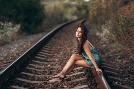 Woman Sitting on Railway Tracks in Natureの写真素材