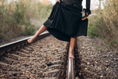 Barefoot Woman Balances on Railway Track in Black Dress