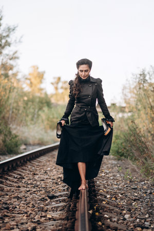 Barefoot Woman Balances on Railway Track in Black Dress