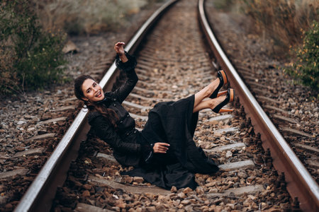 Elegant Woman in Stylish Black Outfit on Train Tracks