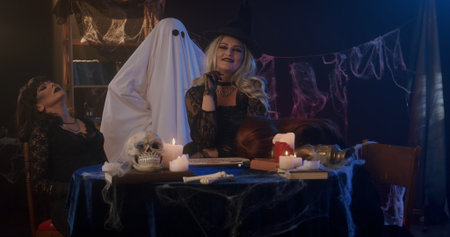 Women in Witch Costumes with Ghost and Skull at Halloween Party