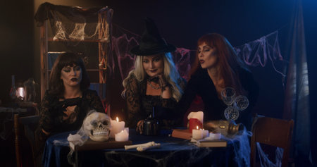 Three Stylish Witches With Candles In Mysterious Settingの写真素材
