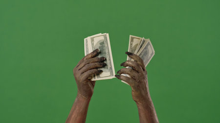Creepy zombie hands hold a stack of cash