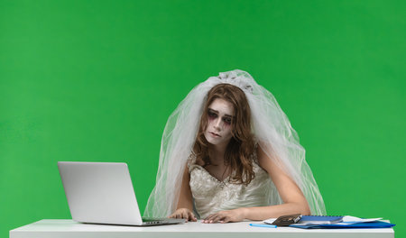 Dead Bride Working on Laptop at Deskの写真素材